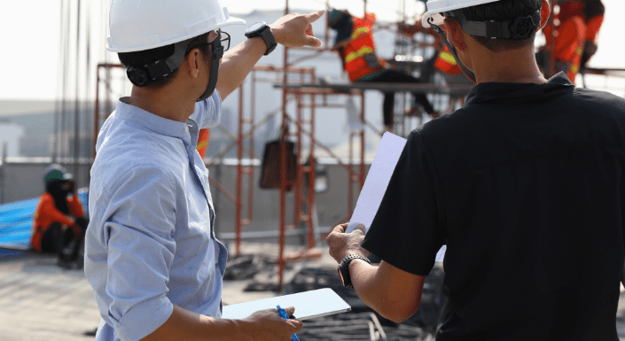 A pair of project managers review progress on a large-scale construction project